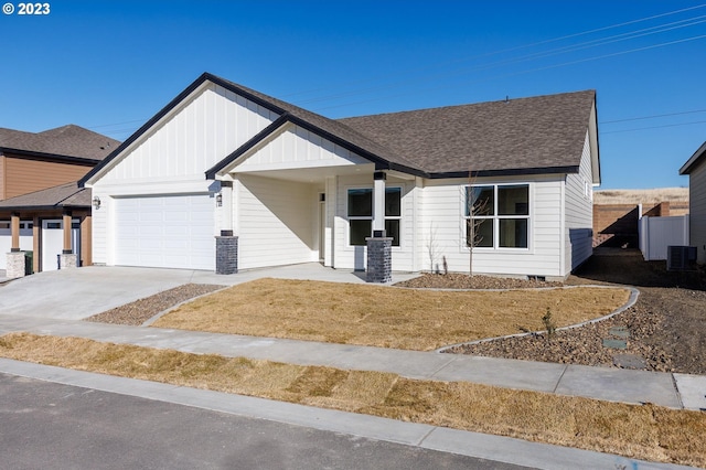 view of front facade with a front yard, a garage, and central AC