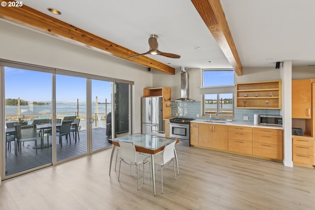 2901 NE Marine Dr Unit C-23, Portland, OR 97211 - kitchen featuring appliances with stainless steel finishes, wall chimney range hood, beamed ceiling, decorative backsplash, and light wood-type flooring