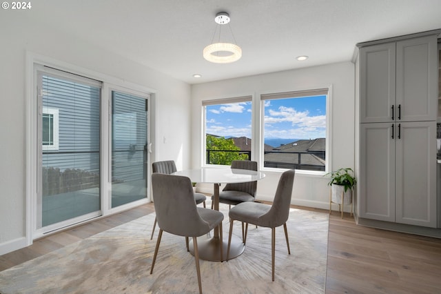 dining space with recessed lighting, light wood-style floors, and baseboards