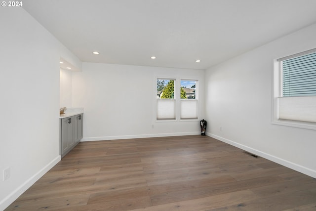 spare room featuring visible vents, light wood-style flooring, and baseboards