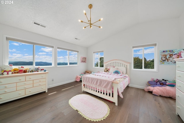 bedroom featuring vaulted ceiling, visible vents, a textured ceiling, and hardwood / wood-style flooring