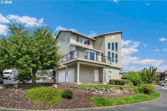 view of front of house featuring a garage and a balcony