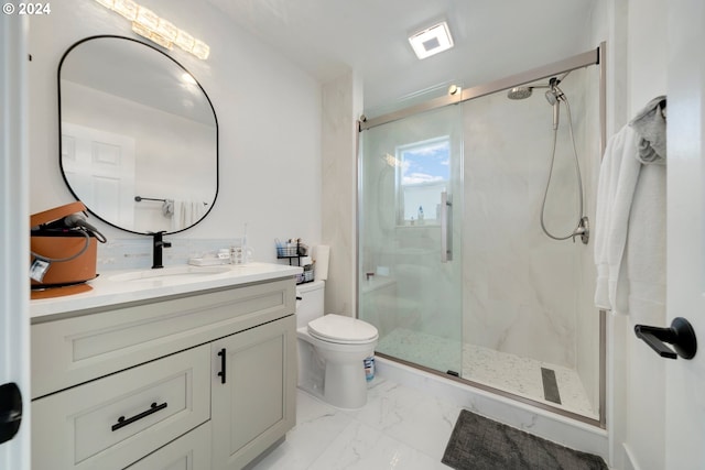 full bath with a marble finish shower, marble finish floor, toilet, and vanity