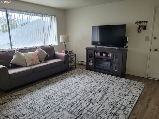 living room with dark hardwood / wood-style floors and a baseboard heating unit