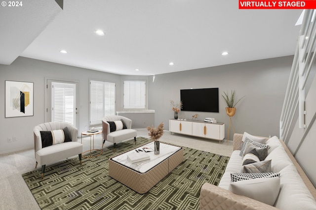 carpeted living area featuring recessed lighting and baseboards