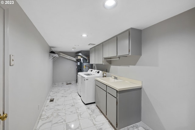 laundry room featuring baseboards, cabinet space, marble finish floor, and washing machine and clothes dryer