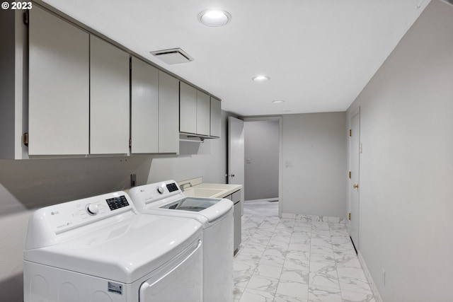 washroom with cabinets, sink, and independent washer and dryer