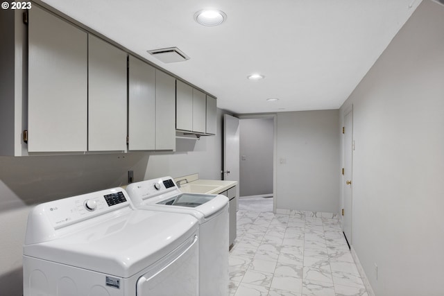 clothes washing area with visible vents, baseboards, cabinet space, marble finish floor, and independent washer and dryer