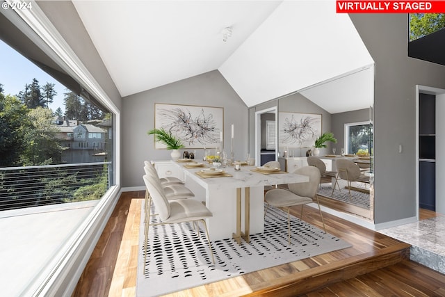 dining room featuring wood-type flooring and vaulted ceiling