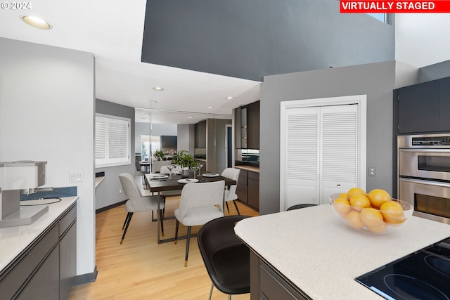 kitchen with light hardwood / wood-style floors, double oven, and black stovetop