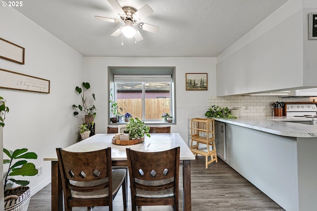 dining space with dark wood-type flooring and ceiling fan
