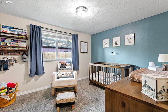 carpeted bedroom with a textured ceiling, baseboards, and a crib