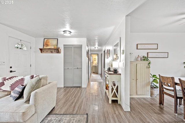 living area with light wood-style flooring and baseboards