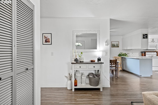interior space featuring wood finished floors, a heating unit, and baseboards
