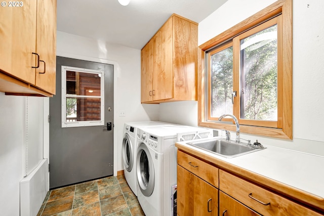 clothes washing area with dark tile flooring, sink, and a healthy amount of sunlight