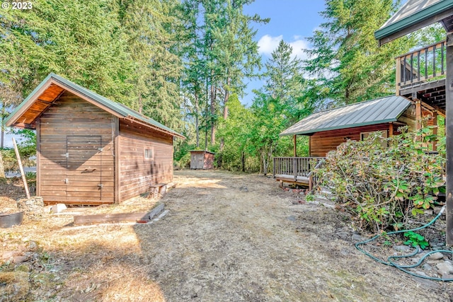 view of yard with a wooden deck and a storage shed