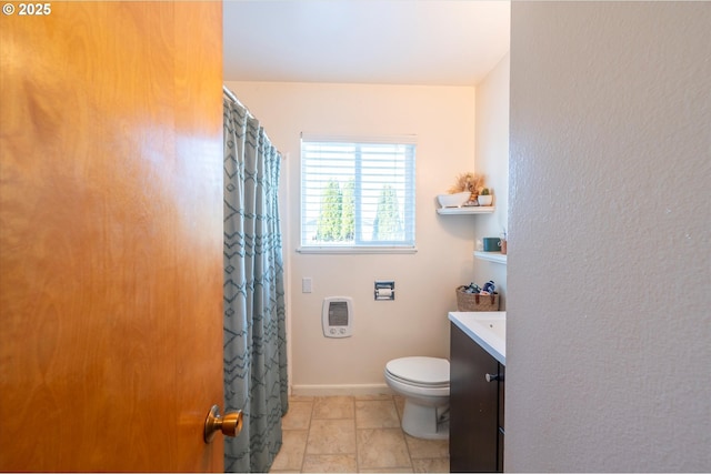 bathroom with vanity, heating unit, tile patterned floors, and toilet