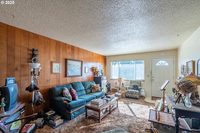 living room with wooden walls and a textured ceiling