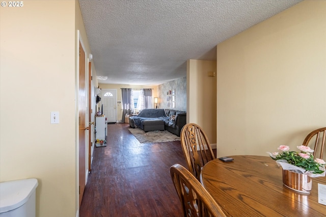 dining area with dark hardwood / wood-style flooring and a textured ceiling