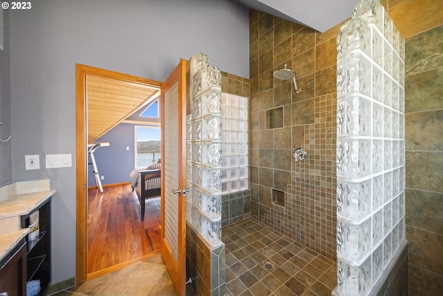 bathroom featuring wood-type flooring and tiled shower