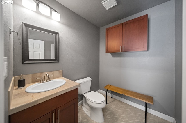 bathroom featuring toilet, tile floors, and vanity with extensive cabinet space