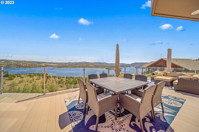 deck with a water view and outdoor lounge area