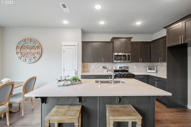 1647 N Millican Creek St, Lafayette, OR 97127 - kitchen featuring appliances with stainless steel finishes, dark brown cabinetry, dark wood-type flooring, a breakfast bar, and decorative backsplash