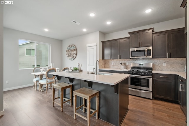 1647 N Millican Creek St, Lafayette, OR 97127 - kitchen featuring appliances with stainless steel finishes, a kitchen bar, light countertops, tasteful backsplash, and dark brown cabinets