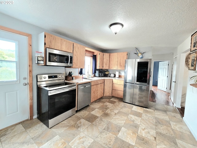 2951 NE Yount Ave, Roseburg, OR 97470 - kitchen featuring stainless steel appliances, light countertops, stone finish floors, a textured ceiling, and a sink