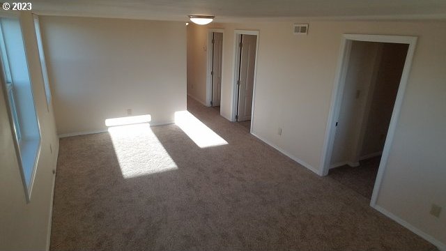 unfurnished room featuring dark colored carpet