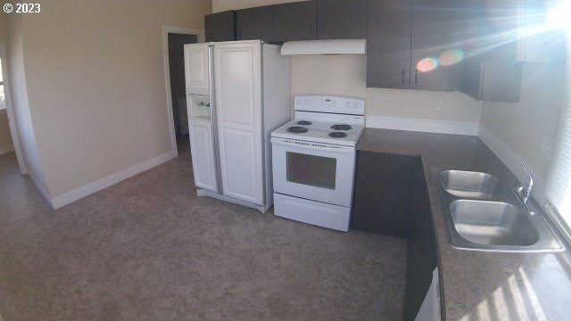 kitchen featuring range hood, sink, white cabinetry, dark carpet, and electric range