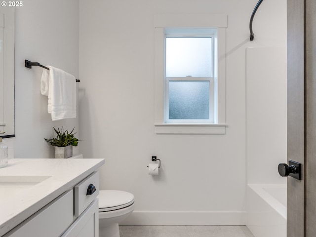 bathroom featuring vanity, toilet, a bath, and baseboards