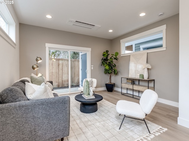 living area with recessed lighting, wood finished floors, and visible vents