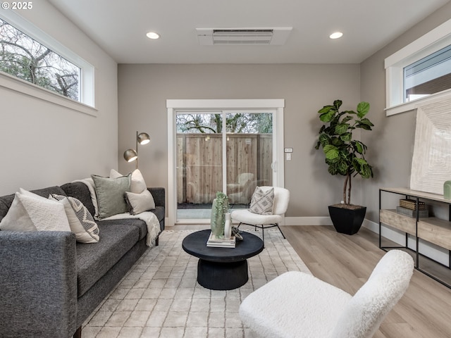 living area with recessed lighting, light wood-style floors, visible vents, and baseboards