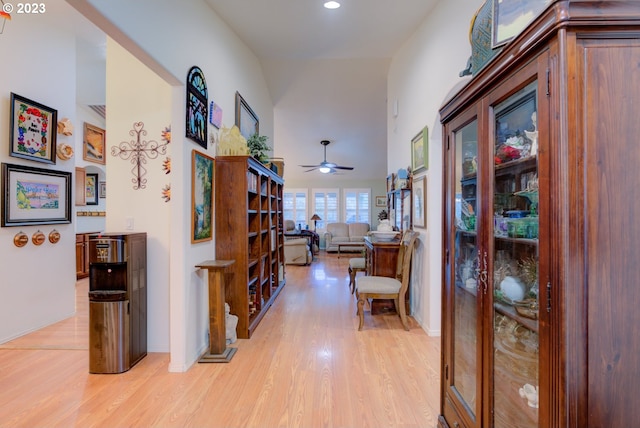 corridor featuring light hardwood / wood-style floors and a towering ceiling