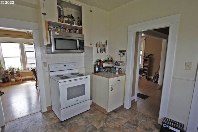 kitchen with backsplash, white electric stove, and white cabinets