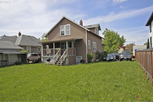 rear view of house with a yard and covered porch