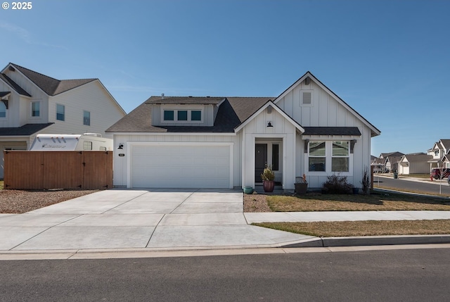 view of front of property featuring fence, a shingled roof, concrete driveway, a garage, and board and batten siding