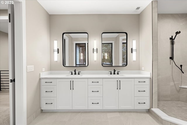 bathroom with tile patterned floors, vanity, and tiled shower