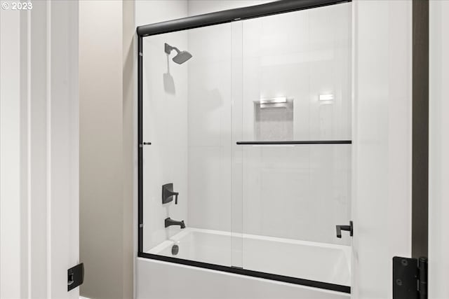 bathroom with bath / shower combo with glass door