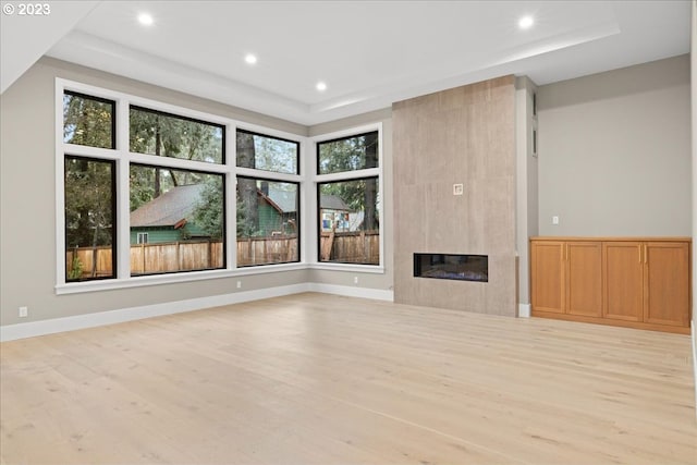 unfurnished living room featuring a fireplace, light hardwood / wood-style flooring, and a healthy amount of sunlight