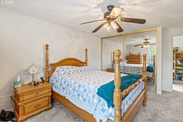 bedroom with a closet, a ceiling fan, a textured ceiling, and light carpet