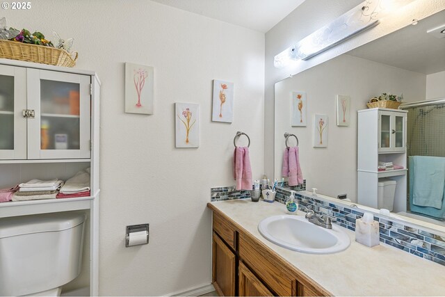 full bath featuring vanity, an enclosed shower, backsplash, and toilet