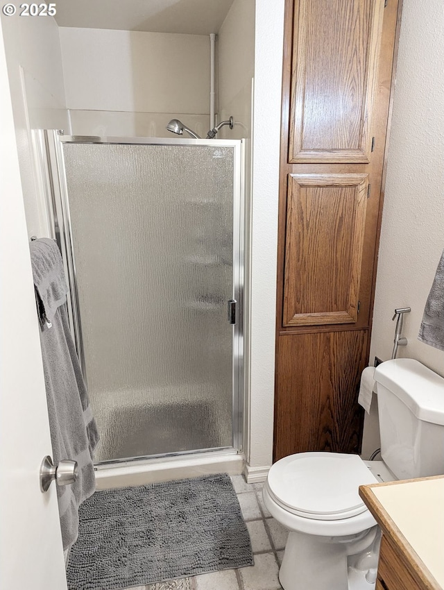 bathroom featuring tile patterned floors, vanity, toilet, and an enclosed shower