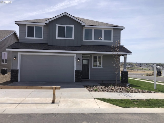 view of front facade featuring central AC unit and a garage