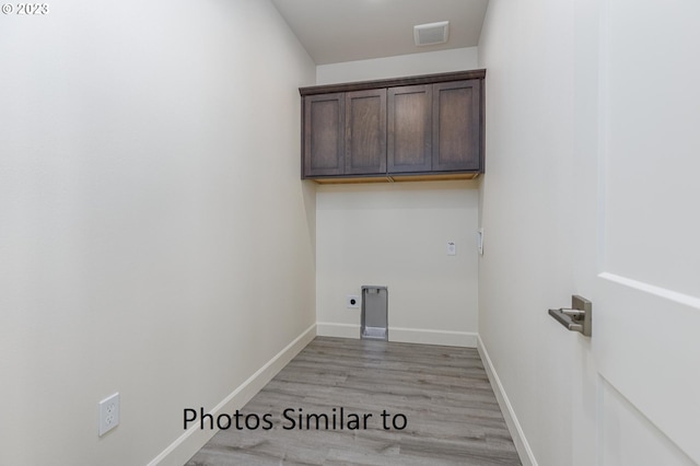 laundry room featuring light hardwood / wood-style flooring, cabinets, and electric dryer hookup