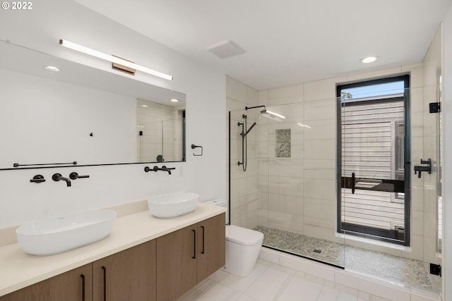 bathroom with walk in shower, tile floors, toilet, and dual bowl vanity