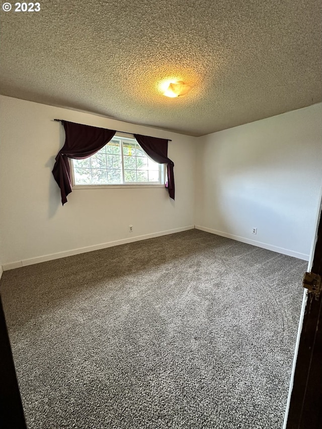 carpeted spare room with a textured ceiling