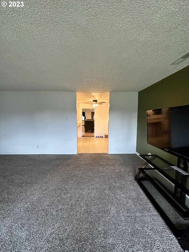 living room with ceiling fan, a textured ceiling, and carpet flooring