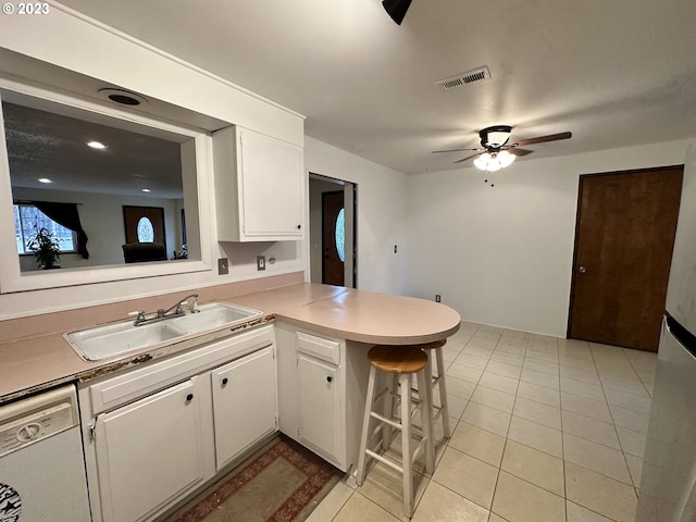 kitchen with sink, a breakfast bar area, white cabinets, white dishwasher, and kitchen peninsula